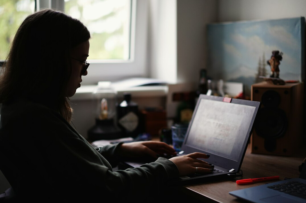 person coding on laptop at home