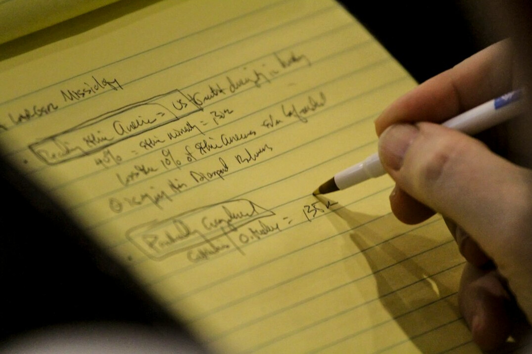 person writing code on paper